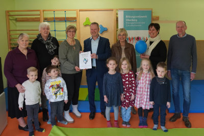 Große Freude in der Marie-Juchacz-Kindertagesstätte in Waldbröl, nachdem Peter Lenz (Aggerenrgie) den Gutschein an die pädagogische Fachkraft Richter übergeben hat. (Foto: OBK). KiTa über die Ballonfahrt, die beide Vorleserinnen (l.) gemeinsam unternehmen werden. (v.l.n.r. Peter Lenz, Ahggerenergie übergibt den letzt bei xy Richter und der Elefantengruppe der KiTa.