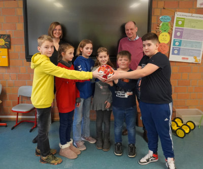 Ganz begeistert von dem signierten Handball des VfL Gummersbach: Schulleiterin Jessica Schudt und Schüler der Gemeinschafts-Grundschule Becke. (Foto: OBK)