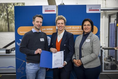 Wissenschaftsministerin Ina Brandesüberreicht den Förderbescheid an Birgit Steuer, Leiterin des Bildungsbüros Oberberg und der Koordinator des zdi-Zentrums investMINT Oberberg, Bastian Thelen. (Foto: MKW NRW/Ralph Sondermann)